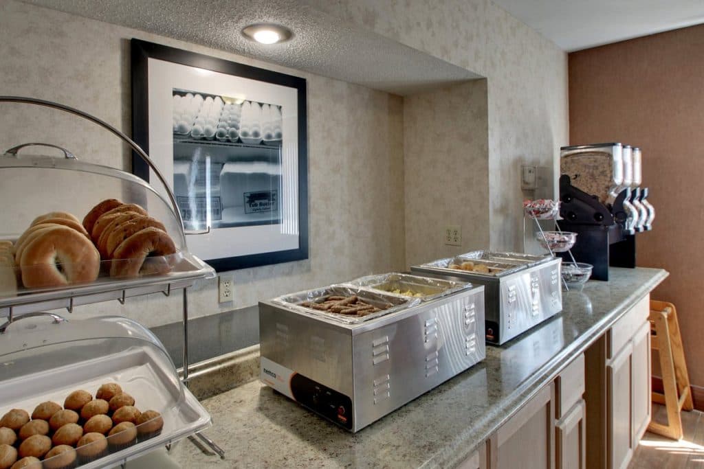 Hotel breakfast area at Angel Inn Central in Branson MO with a continental buffet, pastries, hot food trays, and coffee service