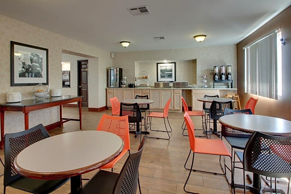 Angel Inn Central breakfast area in Branson MO with round tables, colorful chairs, and a self serve breakfast station
