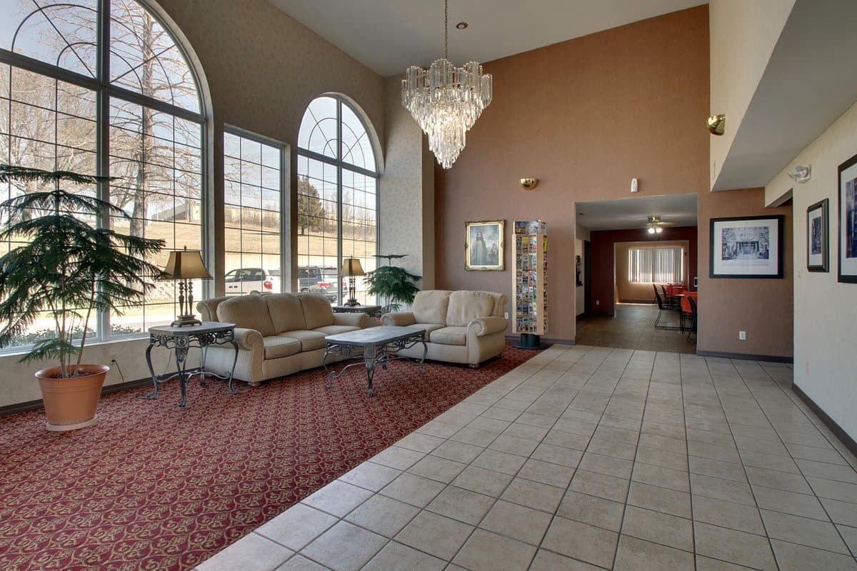 Hotel lobby with front desk and arched windows at Angel Inn Central