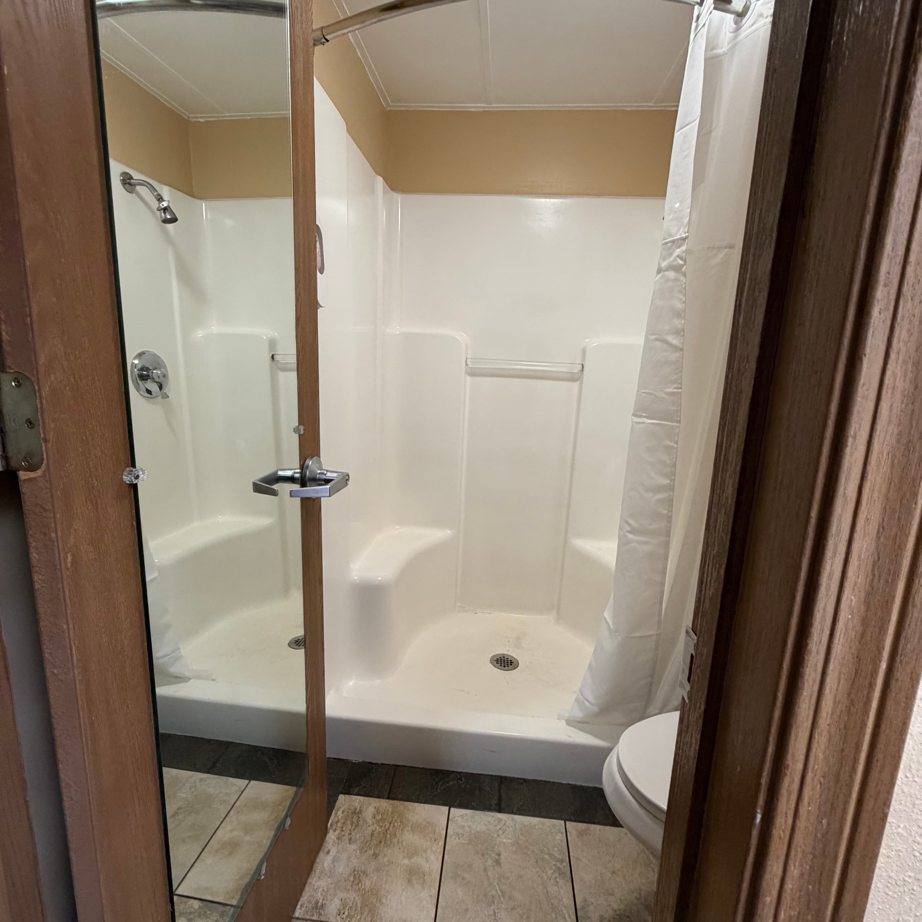 Renovated walk-in shower bathroom at Angel Inn Central with grab bar and shower seat