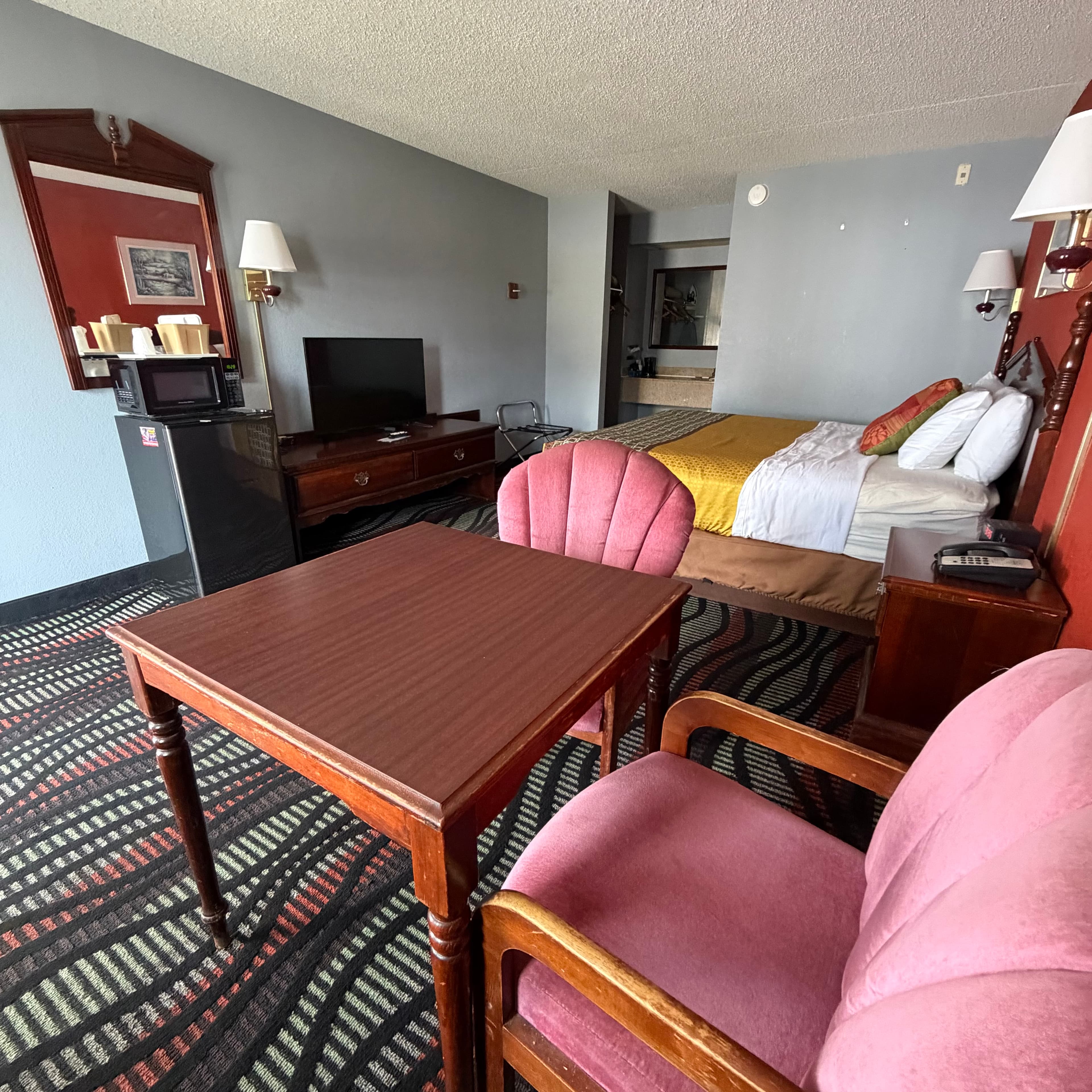 Renovated king guest room at Angel Inn Central with a king bed, table and chairs, and in-room amenities